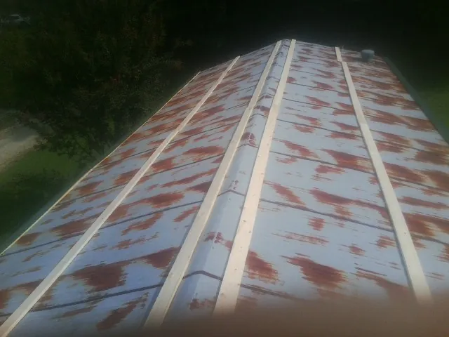 Rusted metal roof panels with new wood purlins before replacement — Storm Damage Roof Repair in Blessing by Roofing Brothers